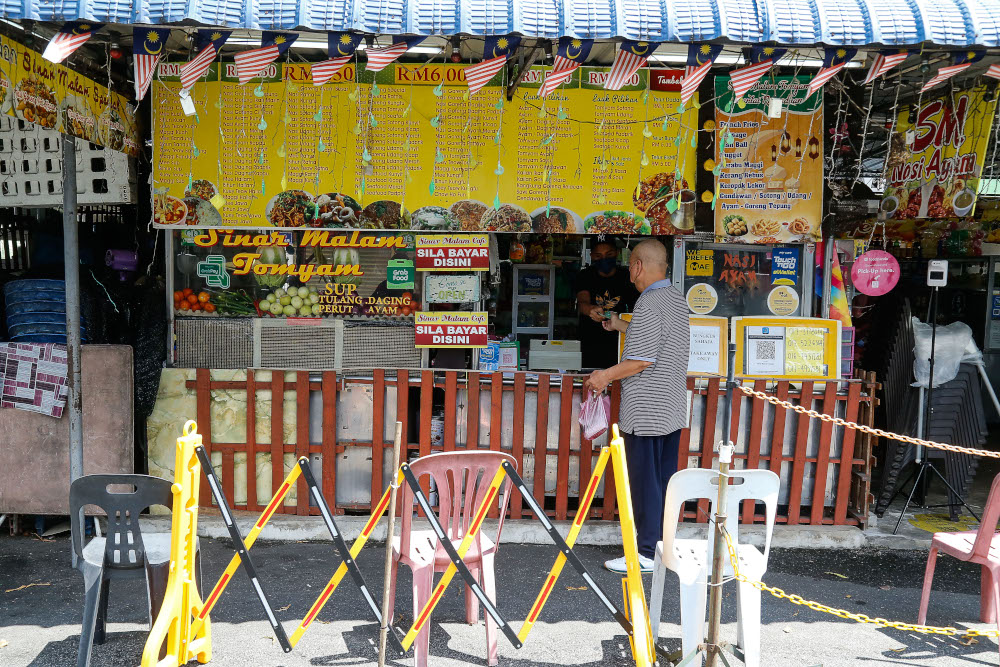 A patron packs food to go at Sinar Malam Cafe in Taman Tun Sardon, Penang, August 11, 2021. u00e2u20acu2022 Picture by Sayuti Zainudin