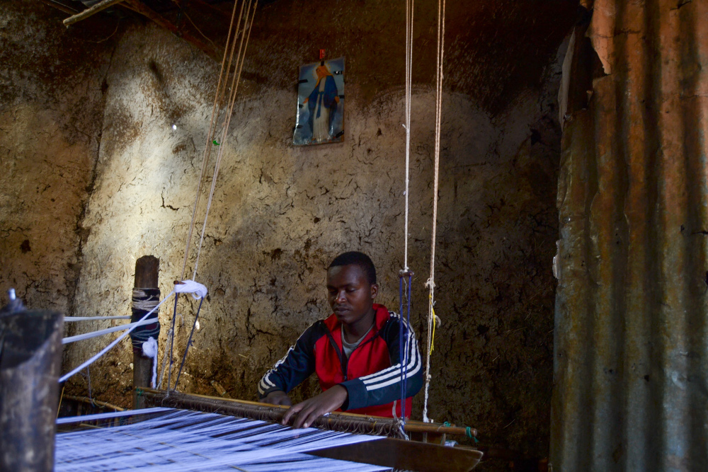 A teenage boy handweaves a traditional Ethiopian scarf in Addis Ababa March 2021. u00e2u20acu201d Thomson Reuters Foundation pic