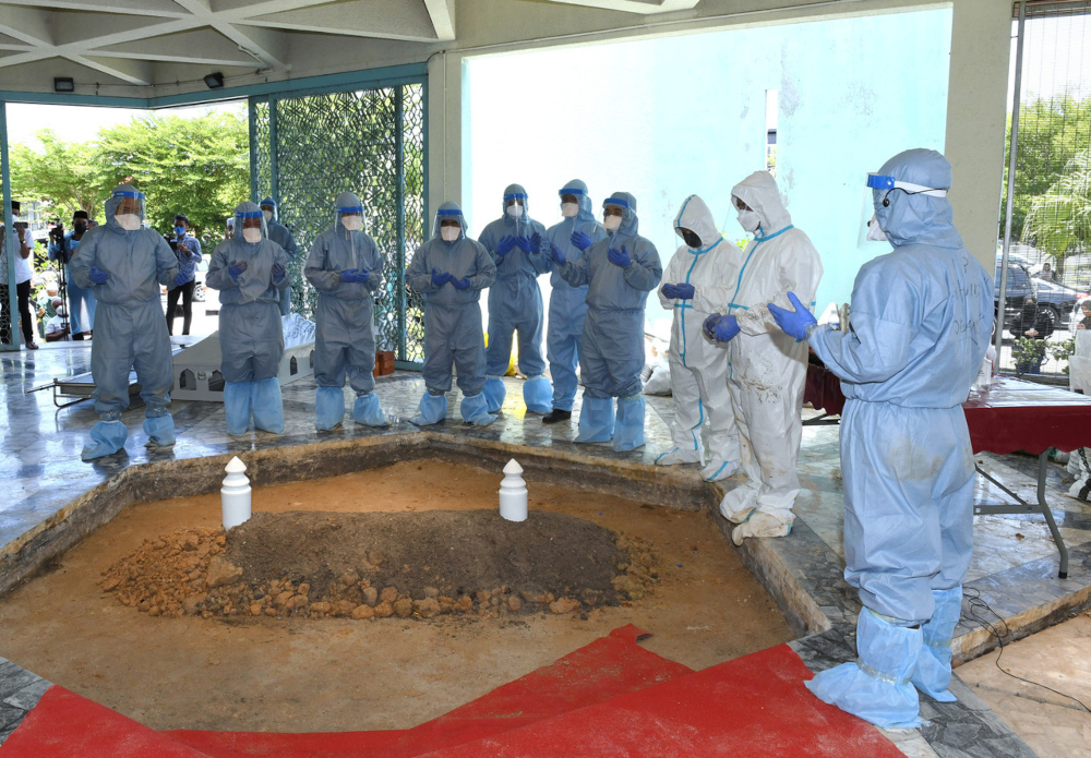 Family members offer prayers after the body of Tun Sakaran Dandai was buried at the Sabah Warriorsu00e2u20acu2122 Mausoleum August 30, 2021. u00e2u20acu201d Bernama pic