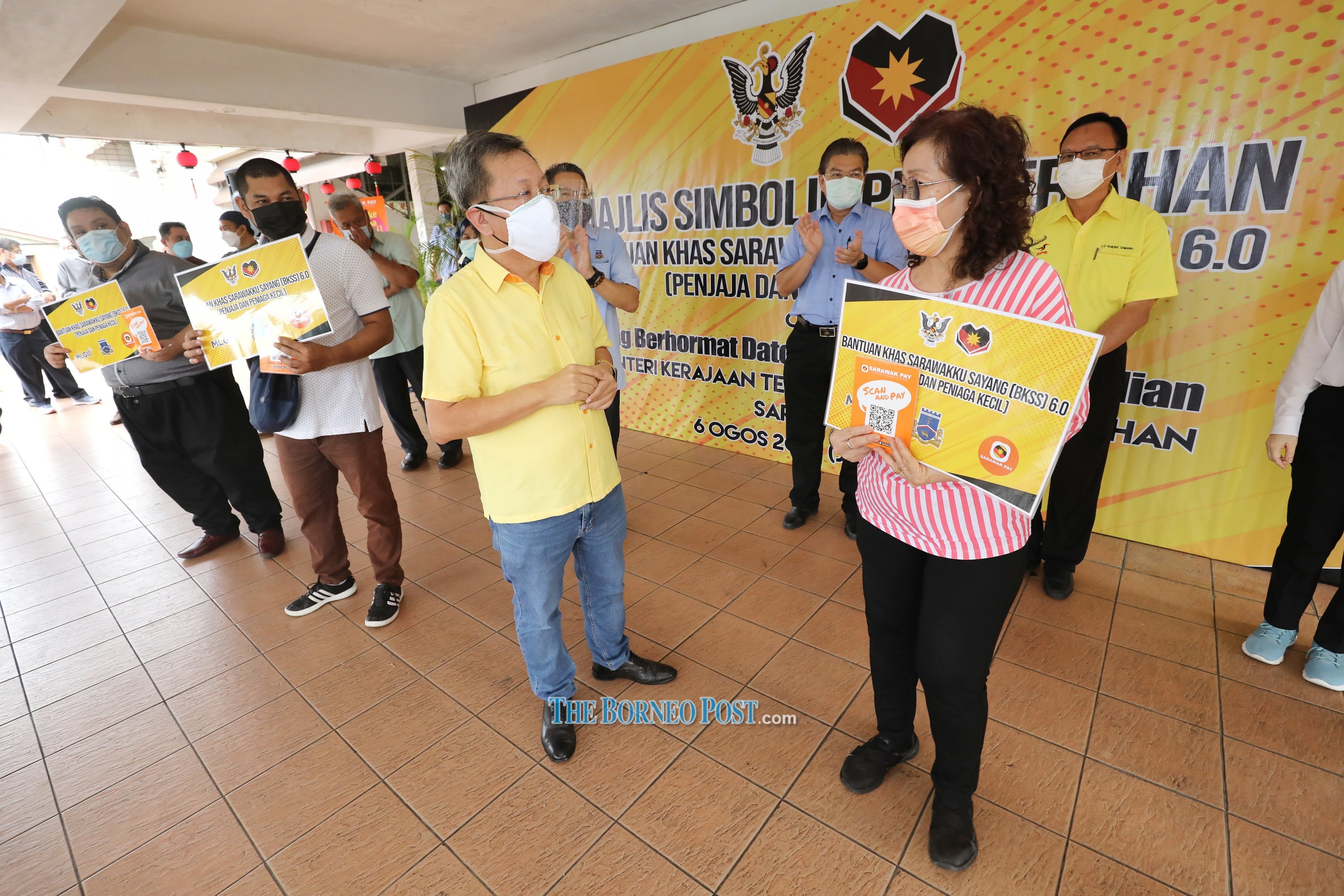 Dr Sim (second right) greets a representative during the symbolic handover ceremony. u00e2u20acu201d Picture by Chimon Upon/Borneo Post