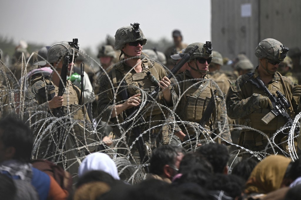 US soldiers stand guard behind barbed wire as Afghans sit on a roadside near the military part of the airport in Kabul on August 20, 2021, hoping to flee from the country after the Talibanu00e2u20acu2122s military takeover of Afghanistan. u00e2u20acu201d AFP pic