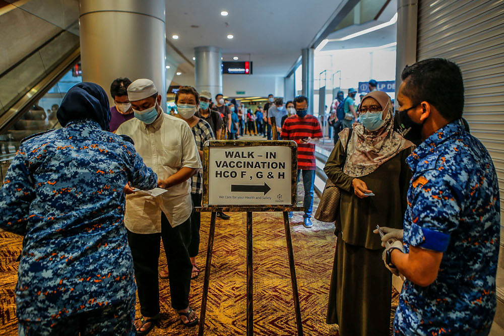 Walk-in vaccine recipients queue up for registration for their Covid-19 jabs at the Kuala Lumpur Convention Centre vaccination centre, August 2, 2021. u00e2u20acu2022 Picture by Hari Anggara