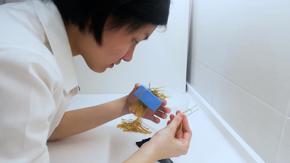 Beh simulates the wick system of the desalination pod. ― Picture courtesy of James Dyson Award