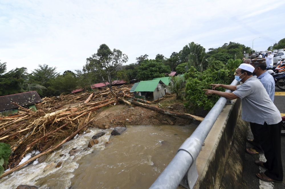 People look at damaged chalets located near Titi Hayun following flash floods in Yan, Kedah August 19, 2021. u00e2u20acu201d Bernama pic