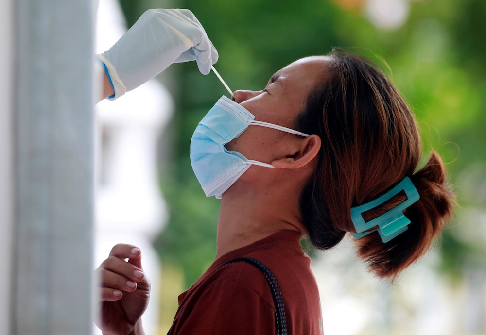 A woman gets a free Covid-19 test after queueing overnight at a temple in Bangkok, Thailand July 10, 2021. u00e2u20acu201d Reuters pic