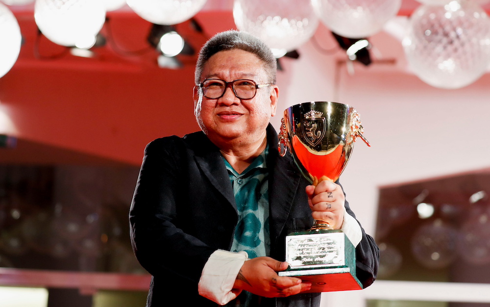 Director Erik Matti poses with the trophy he received on behalf of actor John Arcilla, the Coppa Volpi for Best Actor, Venice September 11, 2021. u00e2u20acu201d Reuters pic
