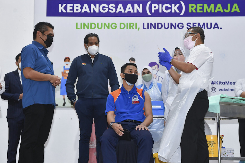 Deputy Health Minister Datuk Dr Noor Azmi Ghazali prepares to vaccinate a student while Health Minister Khairy Jamaluddin and Senior Education Minister Datuk Radzi Jidin look on, Putrajaya September 20, 2021. u00e2u20acu201d Bernama pic