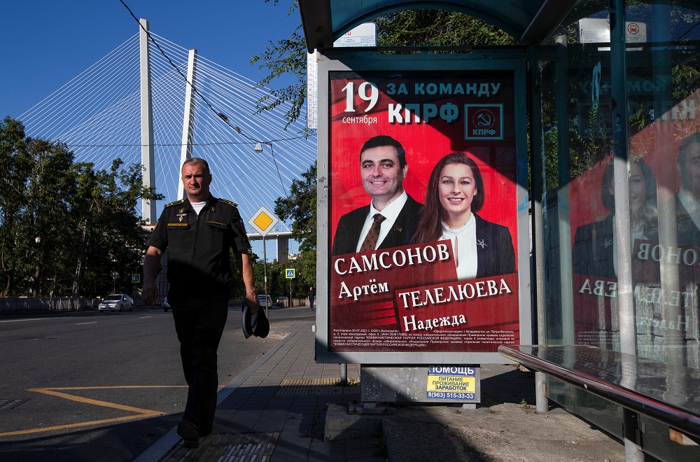 A man walks past a campaign poster of Communist Party candidates ahead of parliamentary election in Vladivostok, Russia September 12, 2021. u00e2u20acu201d Reuters pic