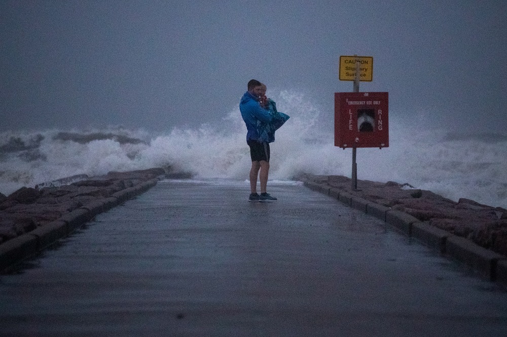 Local resident John Smith holds his 18-month-old son Owen as he stands near breaking waves on a pier ahead of the arrival of Tropical Storm Nicholas in Galveston, Texas September 13, 2021. u00e2u20acu201d Reuters pic