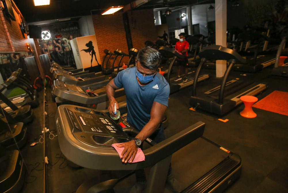 Fitness Lifestyle Gym owner V. Sam Pakiaraj cleans fitness equipment at his gym in Desa Rishah, Ipoh September 1, 2021. — Picture by Farhan Najib