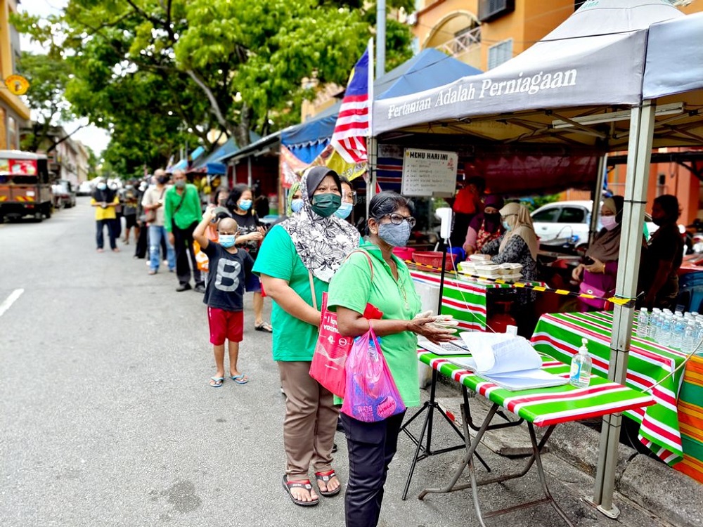 Struggling individuals from the B40 community lined up to collect food while abiding by the Standard Operating Procedures (SOP). u00e2u20acu201d Picture courtesy of McMillan Woods