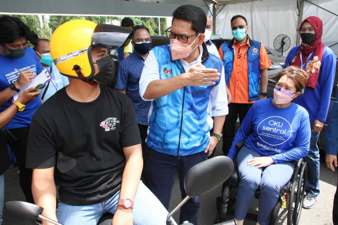 Youth and Sports Minister Datuk Seri Ahmad Faizal Azumu (centre) and OKU Sentralu00e2u20acu2122s president Senator Datuk Ras Adiba Radzi (right) during a visit to the OKU Sentral drive-through vaccination centre at the Johor Baru City Council  Aquatic Centre Septembe