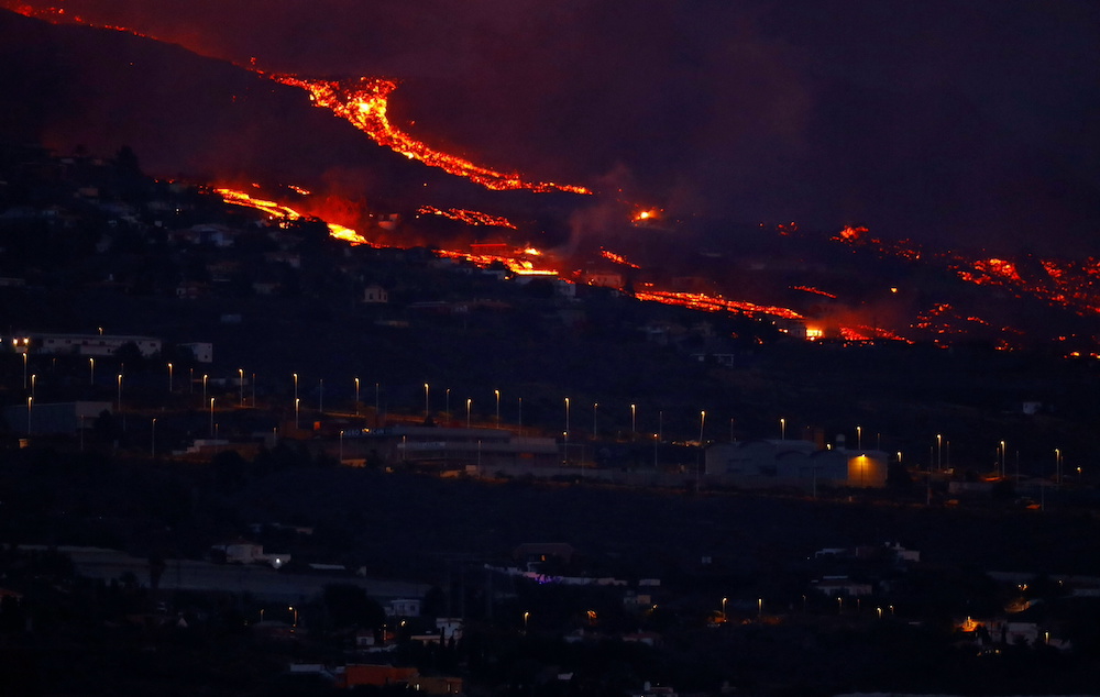 Lava flows behind houses following the eruption of a volcano in the Cumbre Vieja national park, in this picture taken from Tazacorte, on the Canary Island of La Palma September 20, 2021. u00e2u20acu201d Reuters pic