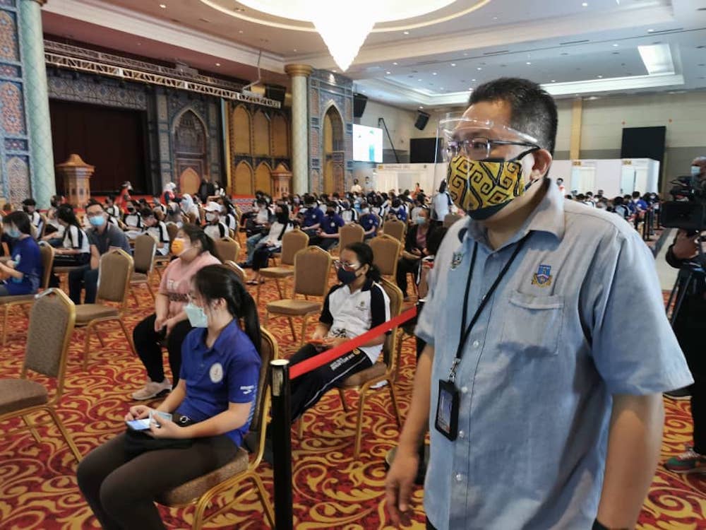 Wee (right) overseeing the vaccination programme. u00e2u20acu201d Borneo Post pic
