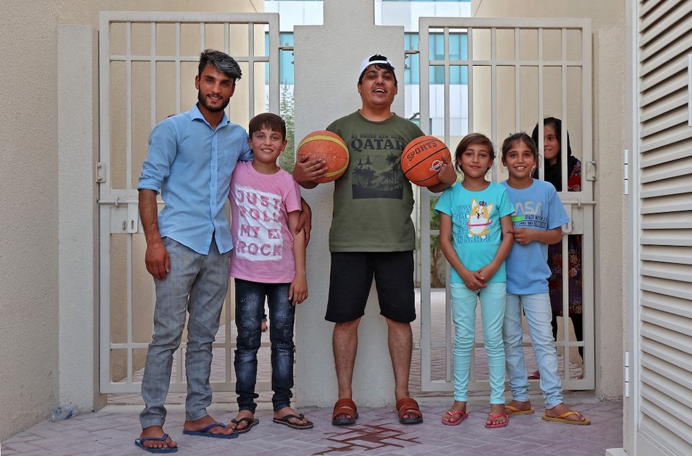 Afghan refugees Khalid Andish (left), 24, and Ahmad Wali Sarhadi (centre), 28, pose for a picture with refugee children outside their accommodation at Park View Villas, a Qataru00e2u20acu2122s 2022 FIFA World Cup residence in Doha, on September 2, 2021. u00e2u20acu201d AFP pic