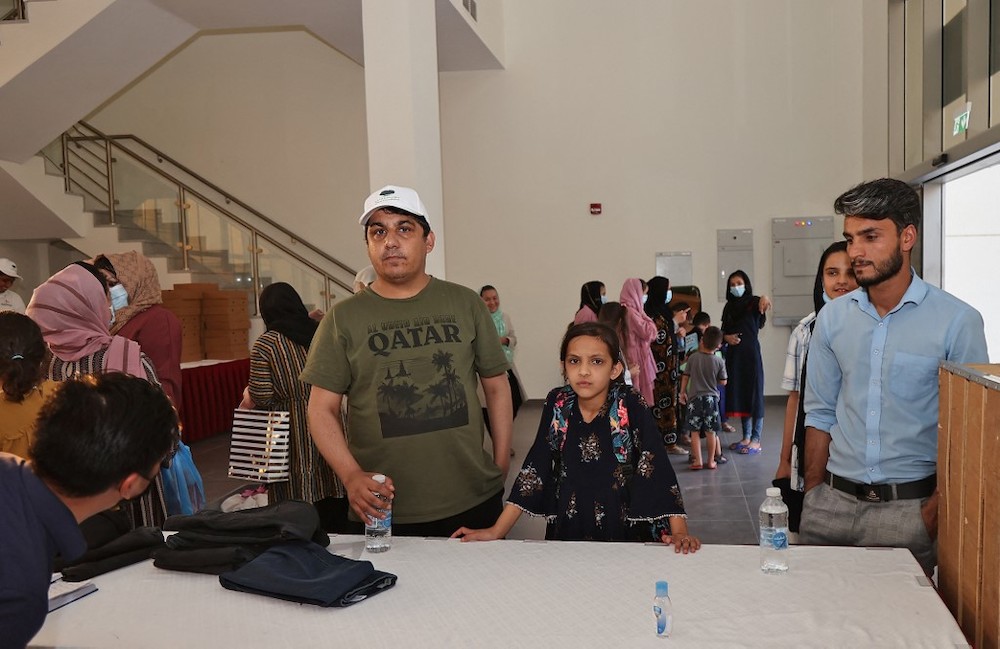 Afghan refugees Khalid Andish (right), 24, and Ahmad Wali Sarhadi, 28, stand with other refugees at a reception centre near their accommodation at Park View Villas, a Qatar’s 2022 FIFA World Cup residence in Doha, on September 2, 2021. — AFP pic