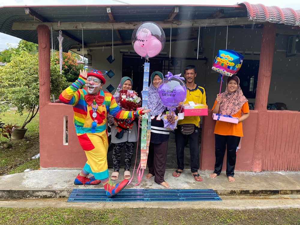 Shaharul (left) brought cheer to a family by delivering a birthday cake and entertaining the family. u00e2u20acu2022 Picture via Facebook/ShaharulHisamBaharuddin