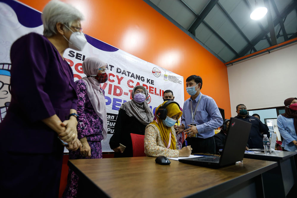Penang state exco Norlela Ariffin (third right) and Permatang Pauh MP Nurul Izzah Anwar looking at the call centre operating procedure during the launch of the Covid-19 Emergency Careline at Dewan Pintar, Guar Perahu, September 9, 2021. u00e2u20acu201d Picture by Say