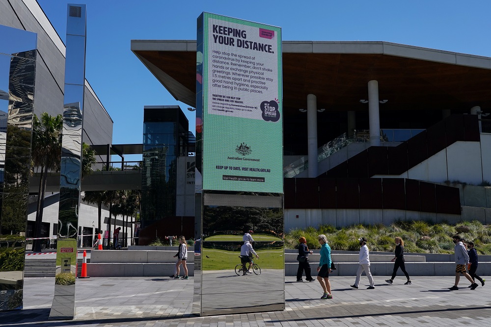 People walk past a public health message encouraging social distancing during a lockdown to curb the spread of the Covid-19 outbreak in Sydney, Australia September 22, 2021. u00e2u20acu2022 Reuters pic
