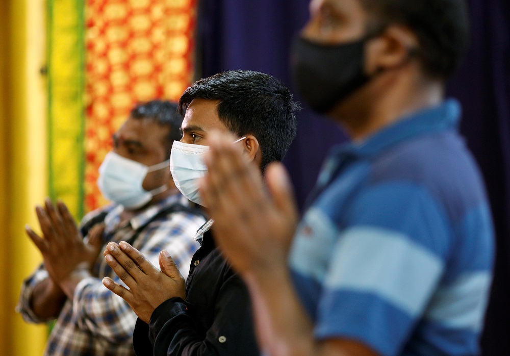 Migrant workers pray at a temple, before enjoying time off at Little India, as part of a pilot programme to allow fully vaccinated migrant workers back to the community in Singapore September 15, 2021. u00e2u20acu2022 Reuters pic
