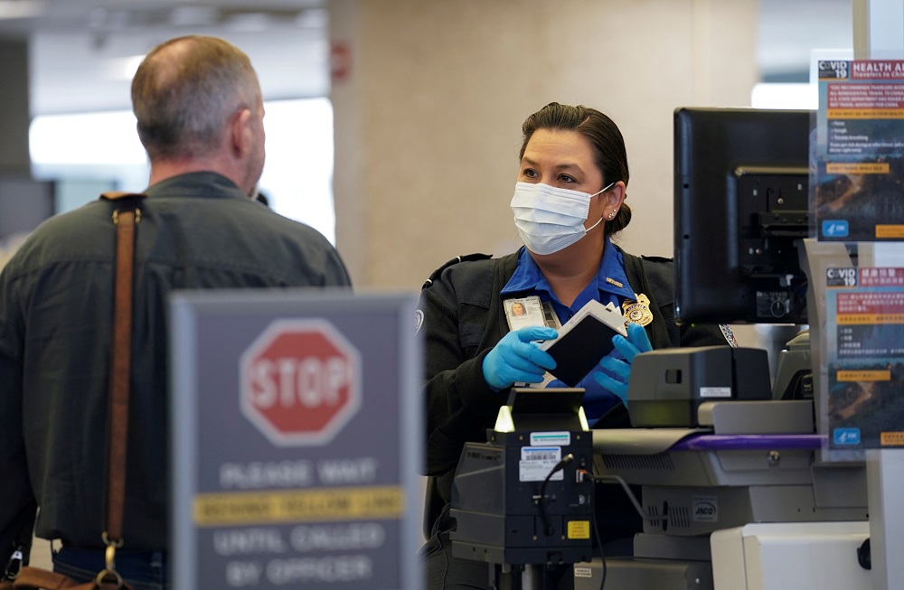 A TSA officer wearing a face mask clears a departing passenger at Dulles International Airport in Dulles, Virginia March 12, 2020. u00e2u20acu2022 Reuters file pic