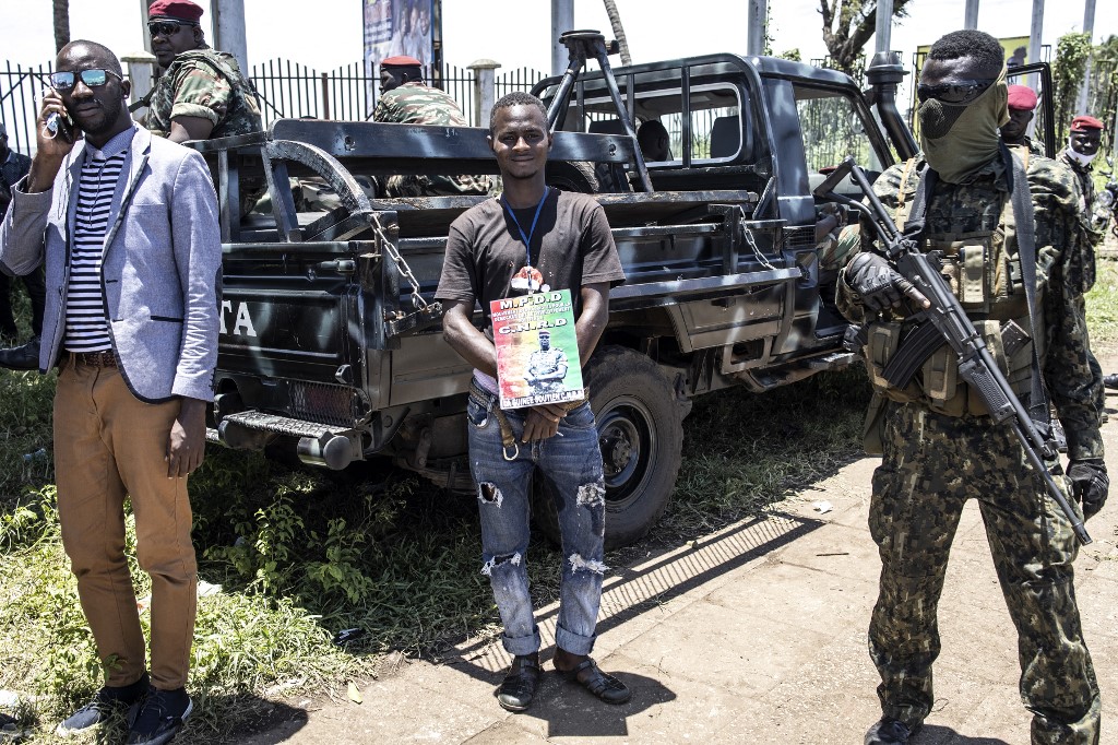 A supporter of junta leader, Colonel Mamady Doumbouya, stands with a portrait of him at the Peoples Palace in Conakry, Guinea on September 11, 2021. u00e2u20acu201d AFP pic