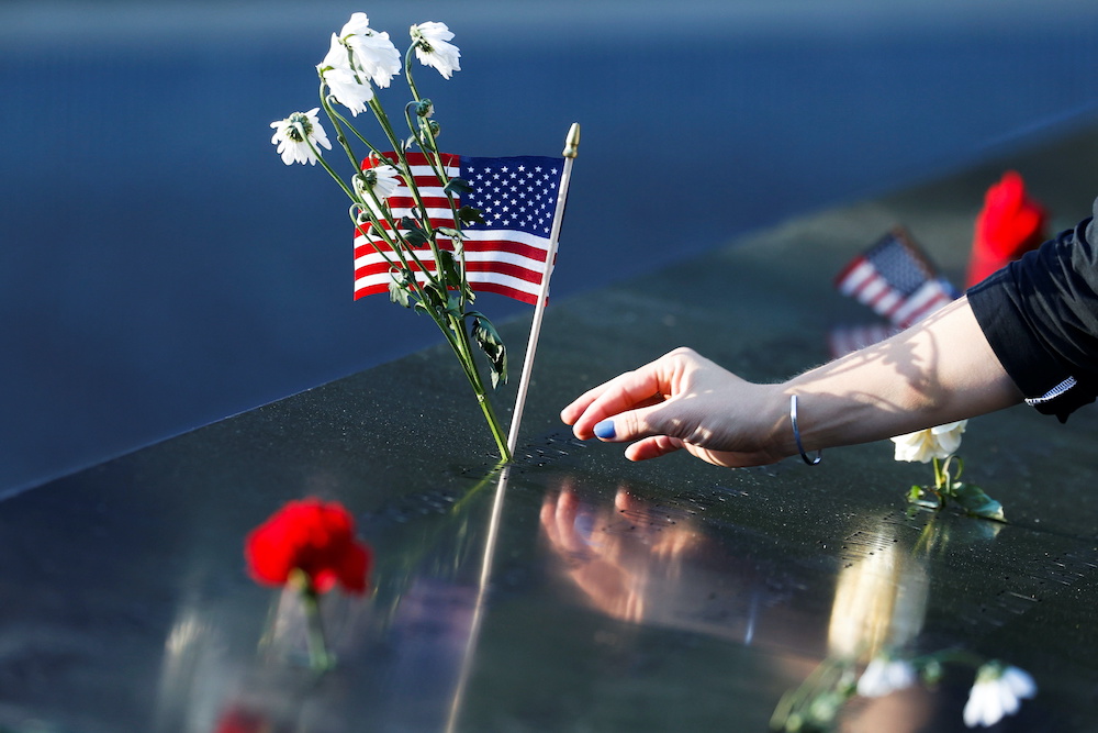 A person places flowers and a US flag on the 9/11 Memorial on the 20th anniversary of the September 11 attacks in Manhattan, New York City, US, September 11, 2021. u00e2u20acu201d Reuters pic