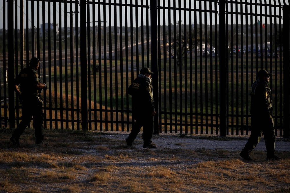 US Border Patrol officers walk along the perimeter fence near the International Bridge between Mexico and the US, where migrants seeking asylum in the US are waiting to be processed, in Del Rio, Texas September 20, 2021. u00e2u20acu2022 Reuters pic
