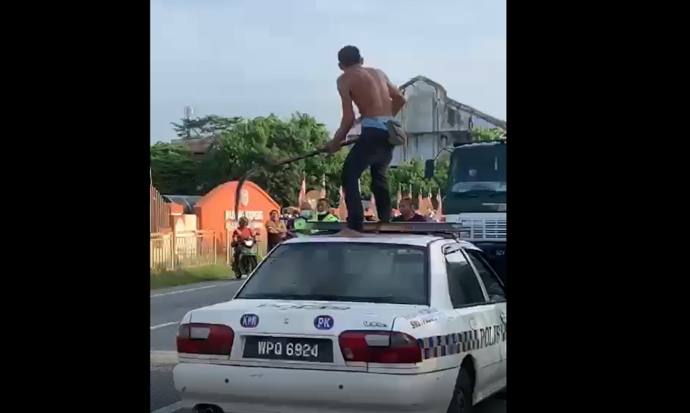 A 61-year-old man, high on drugs, runs amok with a machete and a long sickle at the main road Jalan Ipoh-Kuala Lumpur near the Gopeng Police Station, Kampar, September 8, 2021.n