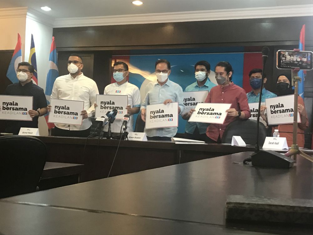 PKR president Datuk Seri Anwar Ibrahim (centre) welcomes activists Adam Adli Abdul Halim (third from right) Asheeq Ali (far left) and Sarah Hadi (far right). u00e2u20acu201d Picture by Radzi Razak