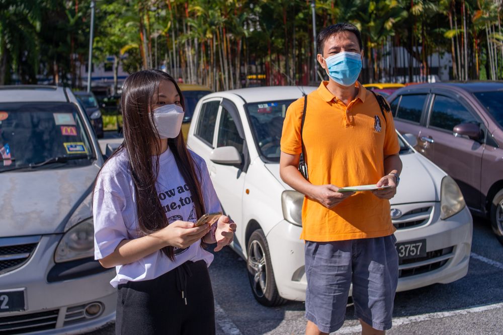 Nigel (right) and Corrine Chong speak to reporters outside the Axiata Arena Covid-19 vaccination centre in Bukit Jalil September 23, 2021. — Picture by Shafwan Zaidon