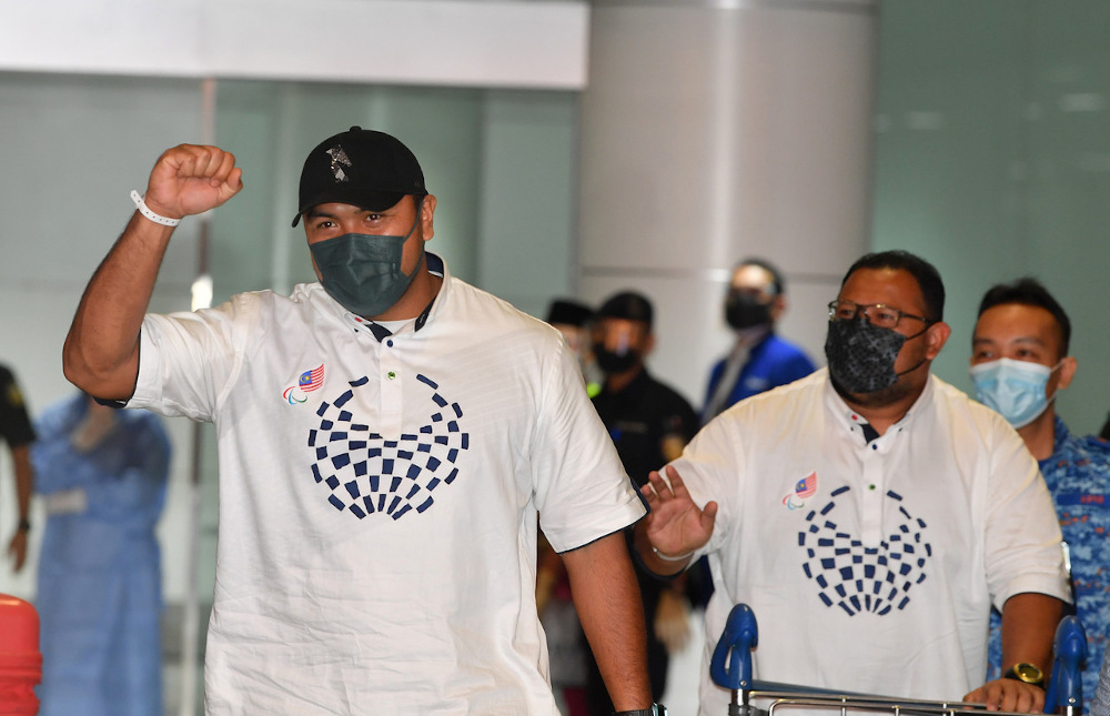 Malaysiau00e2u20acu2122s Muhammad Ziyad Zolkefli (left) and his coach arrive at KLIA after their return from the 2020 Tokyo Paralympics September 3, 2021. u00e2u20acu201d Bernama pic