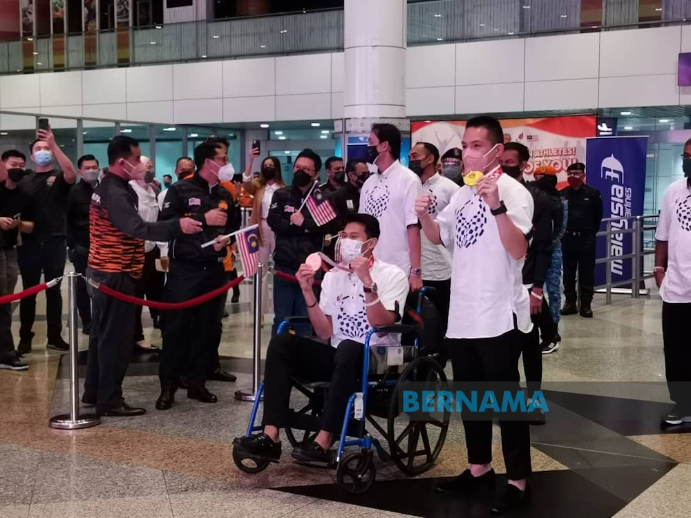 Gold medallists Abdul Latif Romly (T20 (intellectual impairment) menu00e2u20acu2122s long jump) and Cheah Liek Hou (SU5 (physical impairment) menu00e2u20acu2122s singles badminton) pose for a photo after their arrival at KLIA September 6, 2021. u00e2u20acu201d Picture via Twitter/Bernama