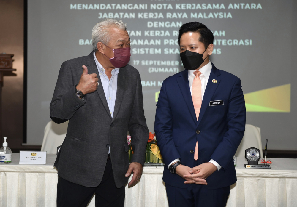 Deputy Chief Minister and Works Minister Datuk Seri Bung Moktar Radin discussing with Deputy Works Minister Datuk Arthur Joseph Kurup after the signing of MoU between the Public Works Department (JKR) and Sabah JKR, September 17, 2021. u00e2u20acu201d Bernama picn