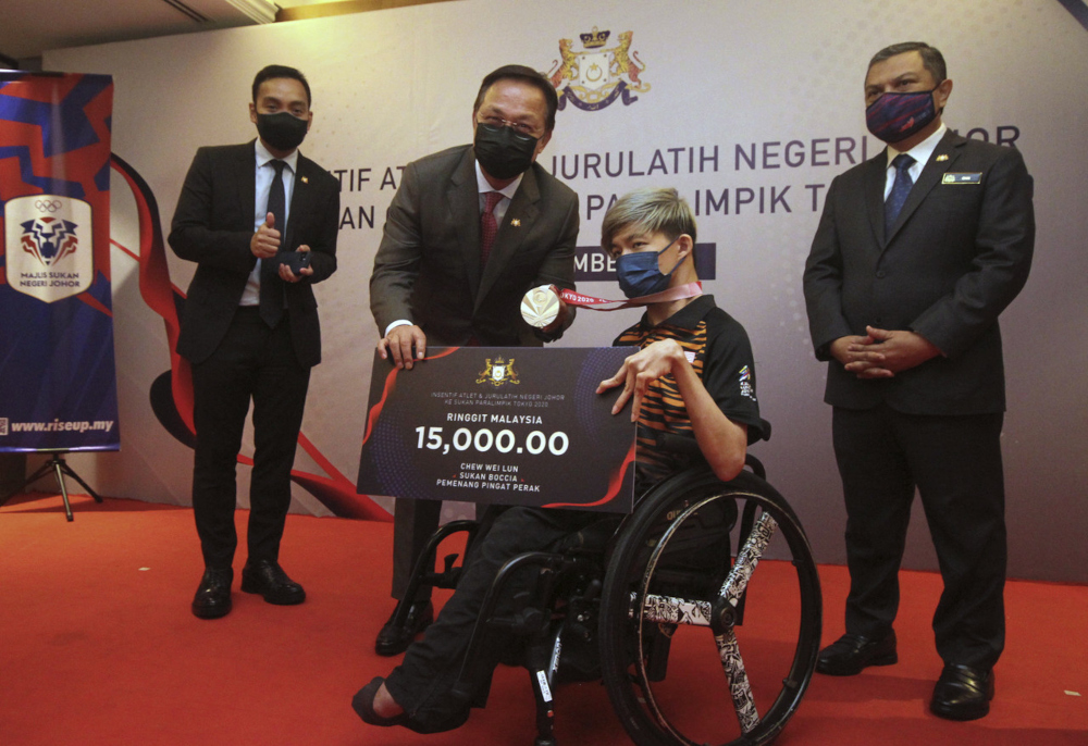 Mentri Besar Datuk Hasni Mohammad hands the incentive to Tokyo 2020 Paralympic Games silver medallist Chew Wei Lun in Johor Baru, September 21, 2021. u00e2u20acu201d Bernama pic 