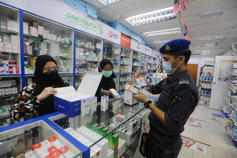 Domestic Trade and Consumer Affairs Ministry personnel conduct checks on pricing of Covid-19 antigen self-test kits at a pharmacy in Sri Gombak September 9, 2021. u00e2u20acu201d Picture by Yusof Mat Isa
