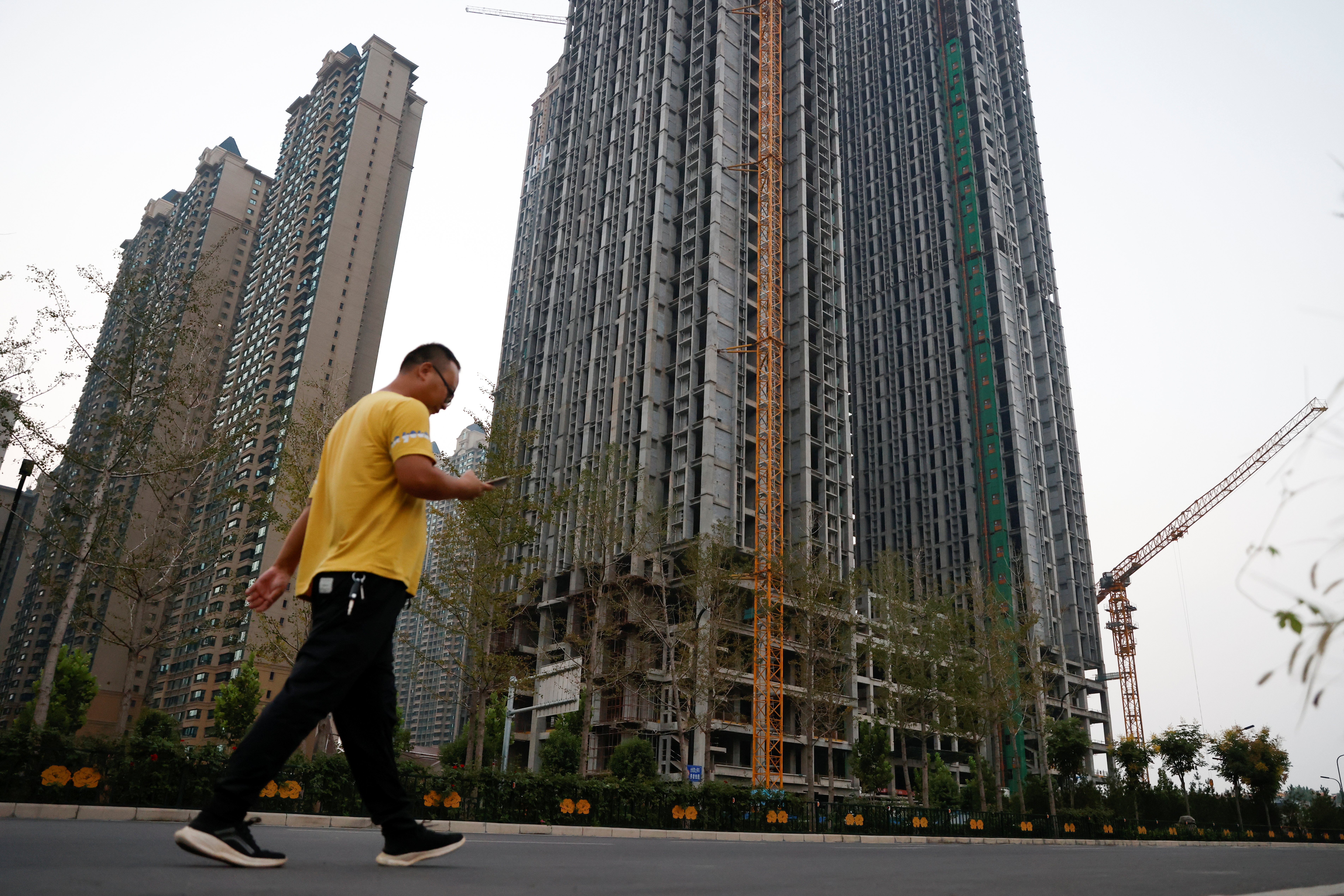 A man walks in front of unfinished residential buildings at the Evergrande Oasis, a housing complex developed by Evergrande Group, in Luoyang September 15, 2021. u00e2u20acu201d Reuters pic