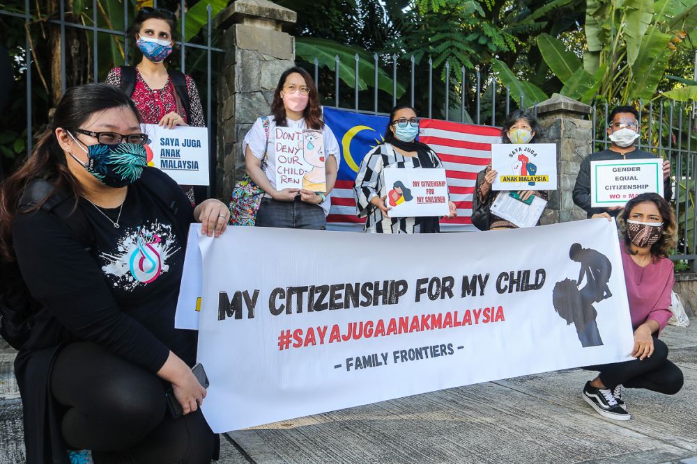 Members of Family Frontiers hold up placards demanding equal citizenship rights for Malaysians outside the Parliament building in Kuala Lumpur September 23, 2021. — Picture by Yusof Mat Isa