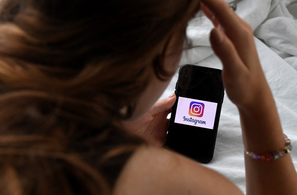 A person looks at a smart phone with an Instagram logo displayed on the screen. u00e2u20acu2022 AFP pic