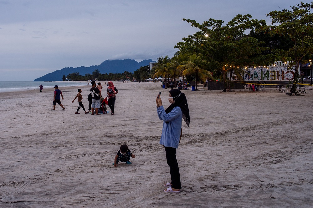 Tourists and local residents spend their leisure time at Pantai Cenang in Langkawi September 15, 2021. 