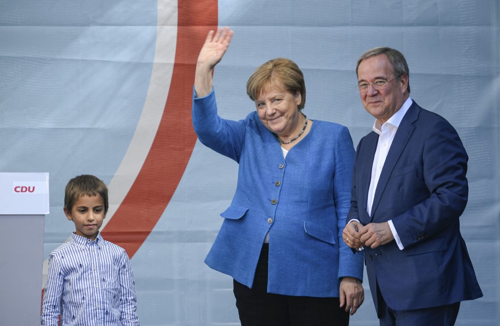 Christian Democratic Union CDU leader and chancellor candidate Armin Laschet (right) and German Chancellor Angela Merkel react on stage during their campaign rally in Aachen, western Germany, on September 25, 2021, one day ahead of the German federal elec