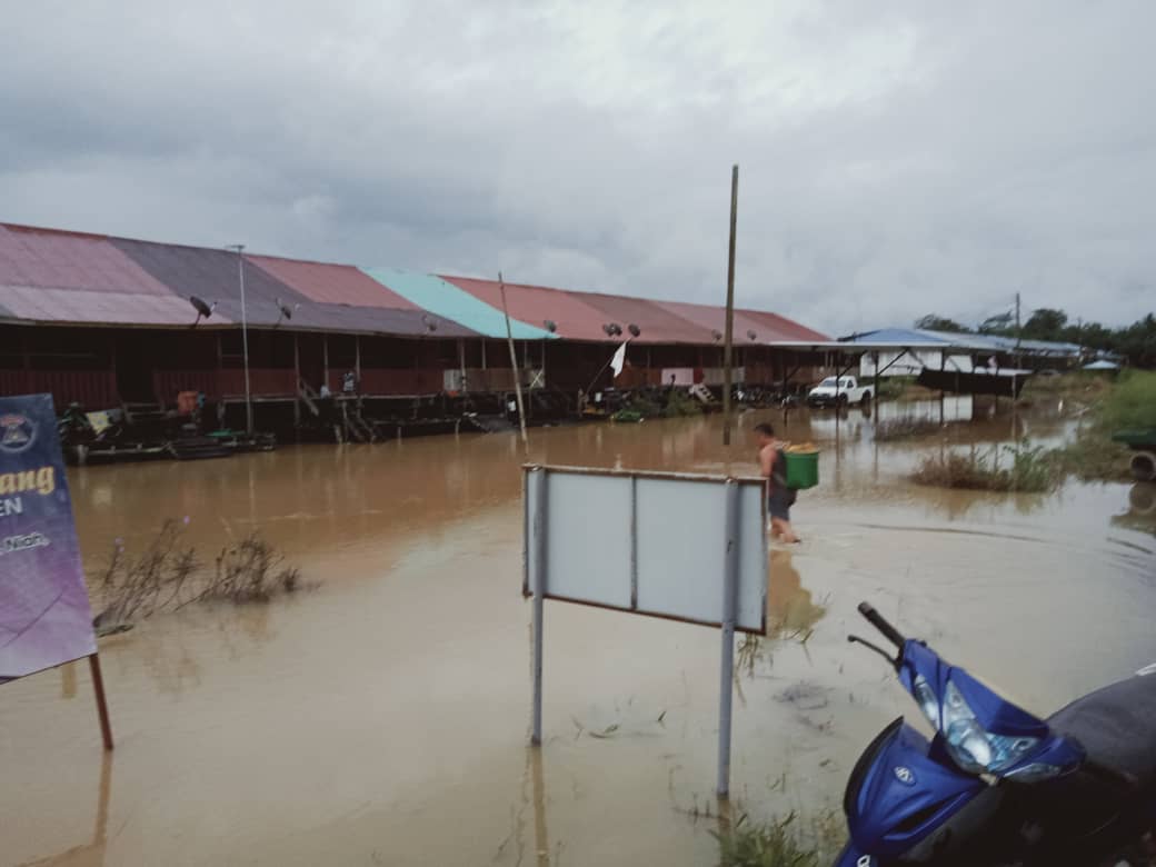 A resident walks through flood waters to Rumah Nelson Ningkan. u00e2u20acu201d Picture courtesy of Miri Fire and Rescue Department