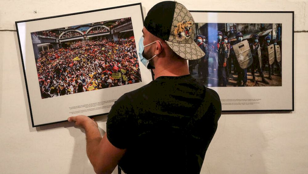 A worker hangs photos for the exhibition u00e2u20acu02dcAnonymous photographer in Myanmaru00e2u20acu2122 ahead of the u00e2u20acu02dcVisa pour lu00e2u20acu2122Imageu00e2u20acu2122 international photojournalism festival in Perpignan, France. u00e2u20acu201d AFP pic