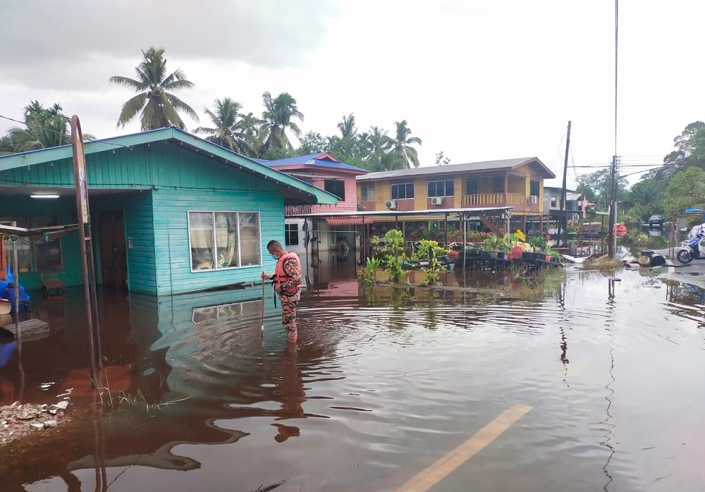A firefighter checks the water level at Kampung Padang Kerbau in Marudi earlier today.  u00e2u20acu201d  Picture courtesy of Miri Fire and Rescue Department via Borneo Post Online