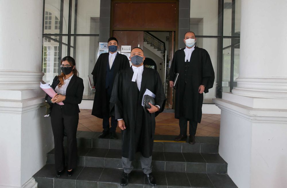 Lawyer Ong Yu Shin (centre) and his team are pictured at the Ipoh High Court September 10, 2021. u00e2u20acu201d Picture by Farhan Najibnn
