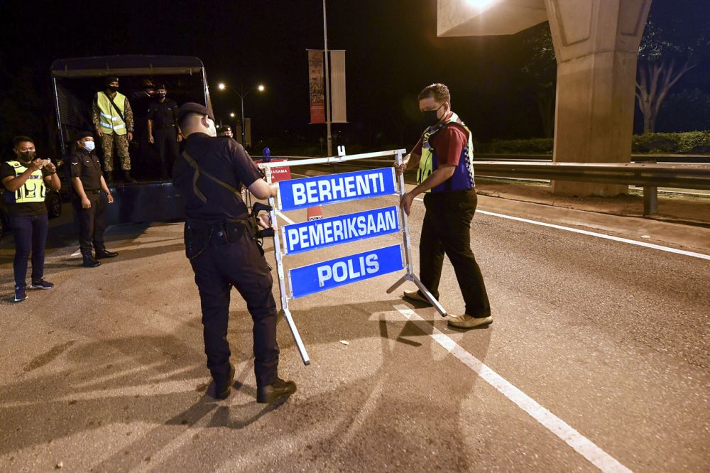 Police personnel are seen removing a roadblock sign in Putrajaya September 10, 2021. u00e2u20acu201d Bernama pic