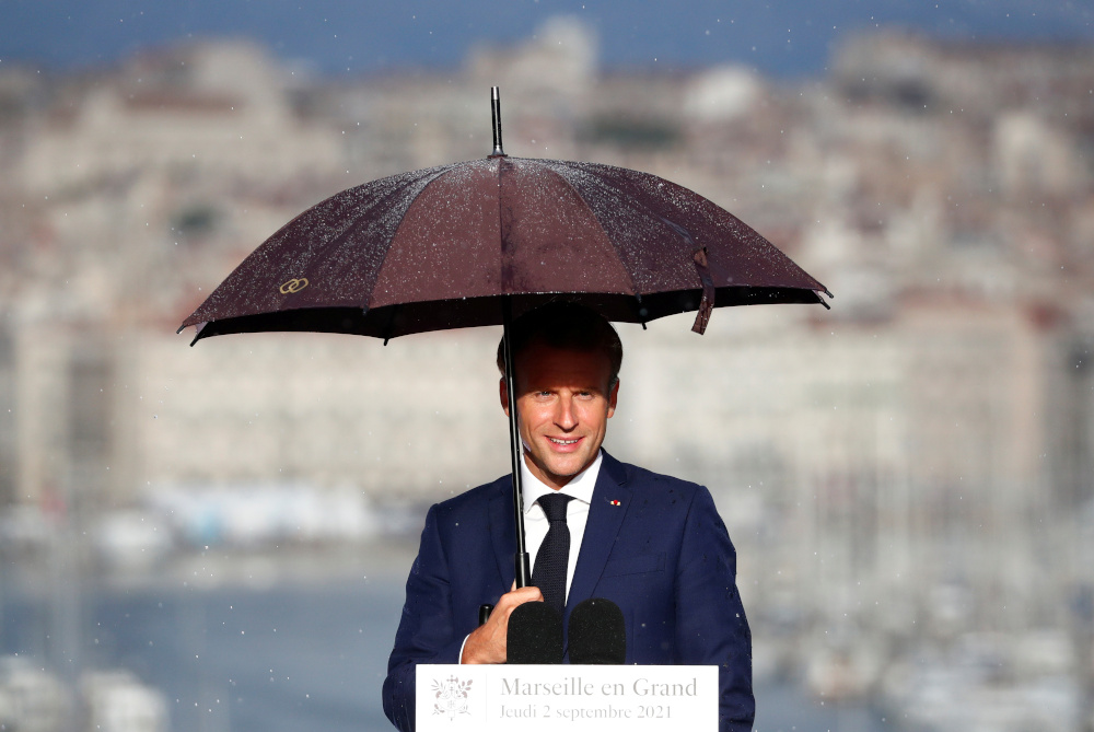 French President Emmanuel Macron holds an umbrella as he delivers a speech at the Palais du Pharo in Marseille September 2, 2021. u00e2u20acu201d Guillaume Horcajuelo/Pool pic via Reuters 