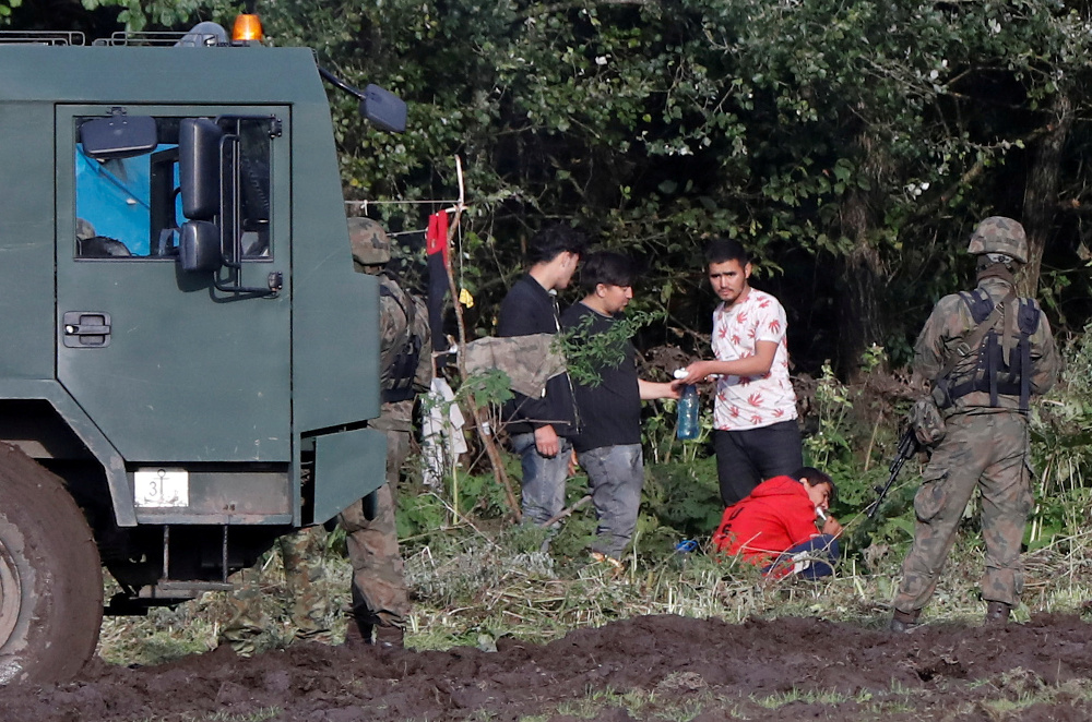 Polish border guard officers stand guard next to a group of migrants stranded on the border between Belarus and Poland near the village of Usnarz Gorny September 1, 2021. u00e2u20acu201d Reuters pic