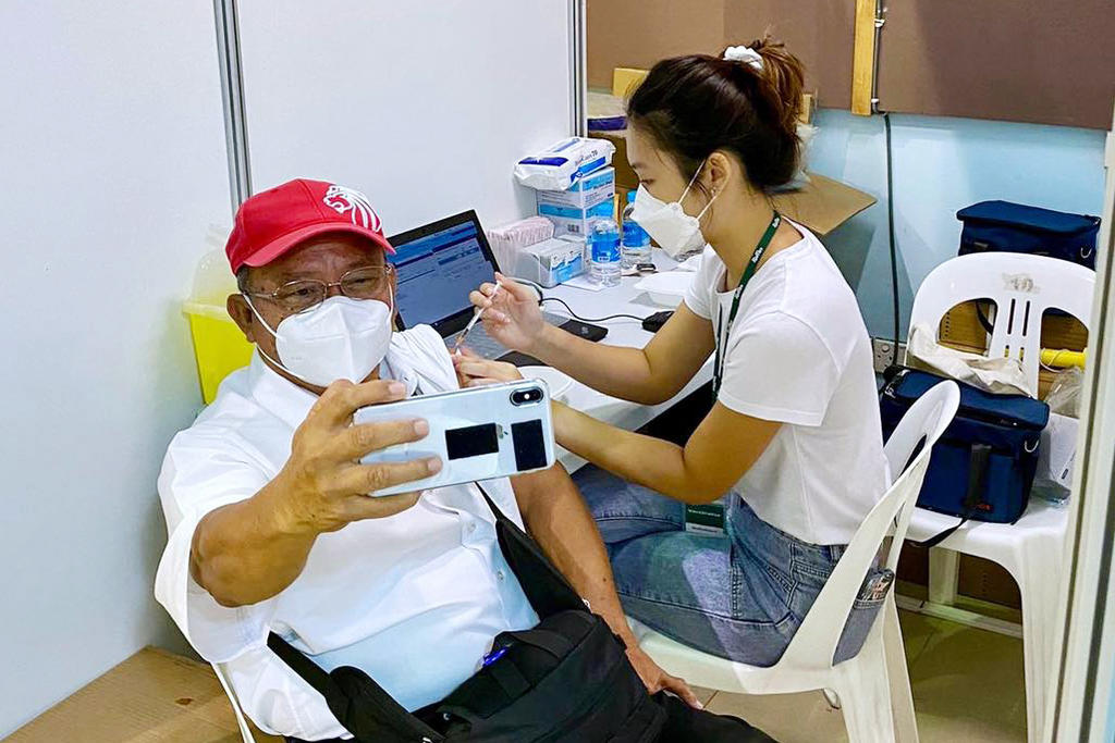 A man getting his Covid-19 booster vaccine shot on September 15, 2021. u00e2u20acu2022 Picture via Facebook/Ong Ye Kung