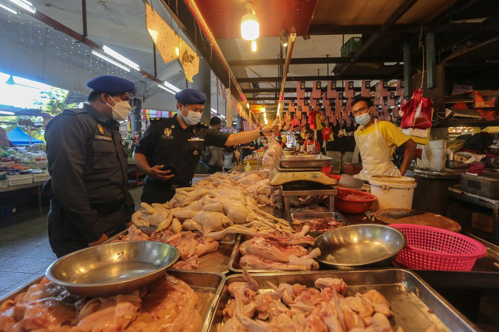 Domestic Trade and Consumer Affairs Ministry enforcement officers conduct checks on prices of chicken at Pasar Awam Moden Seksyen 6 in Shah Alam September 21, 2021. u00e2u20acu201d Picture by Yusof Mat Isa